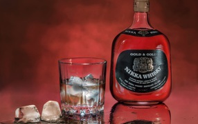 Бутылка Nikka Whisky на столе со стаканом со льдом