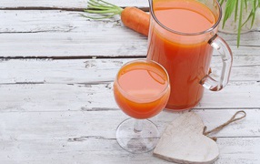Морковный сок в кувшине на столе с  бокалом