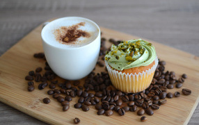 Кофе с аппетитным капкейком стоят на кофейных зернах