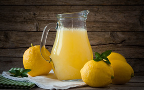 Свежевыжатый лимонад в стеклянном кувшине на столе