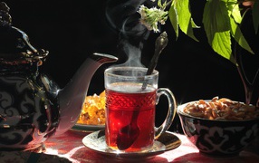 Горячий чай в стеклянной чашке на столе