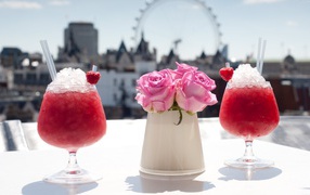 Two cocktails with ice on the table with flowers