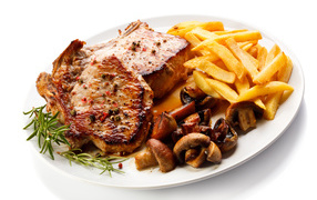 Appetizing piece of grilled meat with French fries and mushrooms