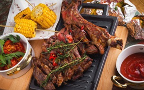 Baked meat with corn and ketchup on the table