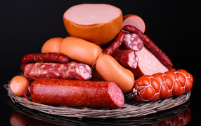 Мясные продукты колбасы и сосиски на черном фоне