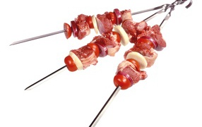 Meat with vegetables for shish kebab on skewers on a white background