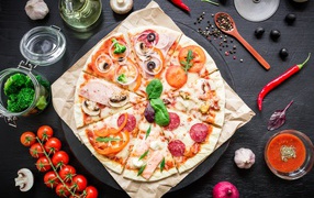 Appetizing pizza on a table with spices and tomatoes