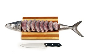 Fresh fish slices on a wooden board with a knife
