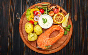 Жареный кусок рыбы с овощами и соусом