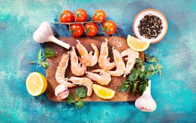 Shrimps on a cutting board with garlic, lemon and spices