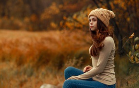 Молодая девушка в синих джинсах и теплой шапке