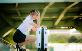 Asian girl stewardess with a suitcase