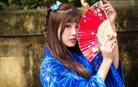 Красивая девушка азиатка с веером в руках