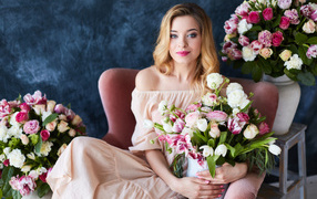 Красивая девушка блондинка сидит с букетом цветов