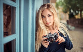 Красивая девушка блондинка с фотоаппаратом 