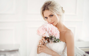 Красивая блондинка невеста с букетом розовых цветов в руках