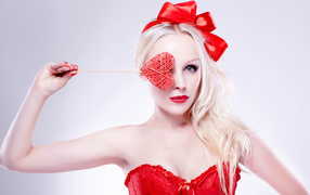 Красивая девушка блондинка в красном наряде с сердечком в руке