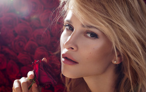 Beautiful blonde girl with a red rose in her hand