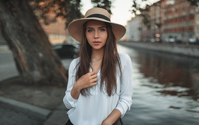 Красивая девушка брюнетка в шляпе у воды