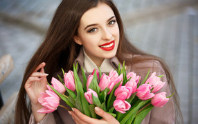 Красивая девушка брюнетка с букетом тюльпанов 