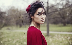 Красивая брюнетка в красном платье с цветком в волосах