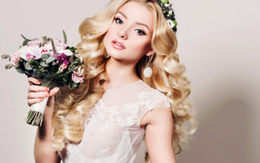 Beautiful gentle blonde with a bouquet of flowers in hands