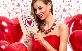 Красивая девушка в красном радуется открытке 