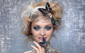 Красивая девушка с ярким макияжем и с бабочками в прическе