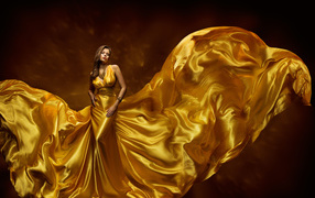 Красивая девушка шатенка в красивом платье золотого цвета