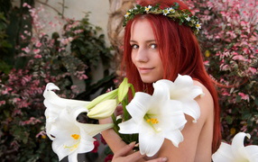 Beautiful red-haired girl with a bouquet of white lilies