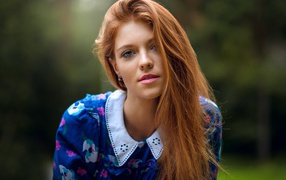 Красивая рыжеволосая девушка с зелеными глазами в красивом платье 