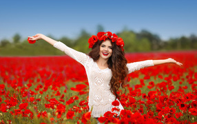 Красивая улыбающаяся девушка в поле с красными маками