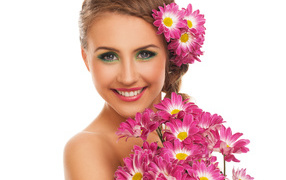 Красивая улыбающаяся девушка с букетом хризантем на белом фоне