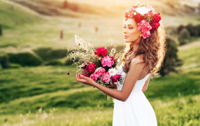 Красивая летняя девушка с букетом цветов и венком на голове