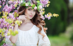 Красивая нежная шатенка в белом платье с венком на голове