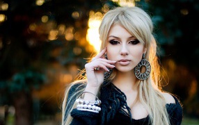 Девушка блондинка с большими серьгами в ушах 