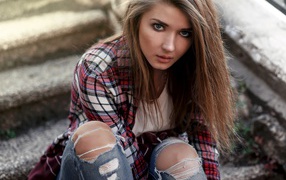 Голубоглазая девушка брюнетка в модных джинсах 