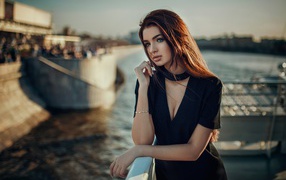 Blue-eyed girl with brunette in black dress by the water