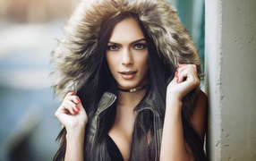 Brunette in a hood with red nails on hands