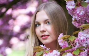 Милая голубоглазая девушка с розовыми цветами 