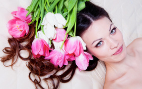 Delicate brown-haired woman with bouquets of tulips in her hair