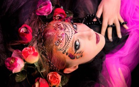 Девушка с блестящим ярким макияжем и розами в волосах
