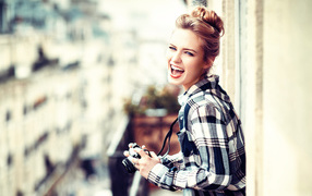 Улыбающаяся девушка в клетчатой рубашке с фотоаппаратом 