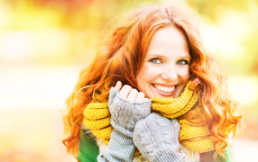 Улыбающаяся рыжеволосая девушка в теплом шарфе