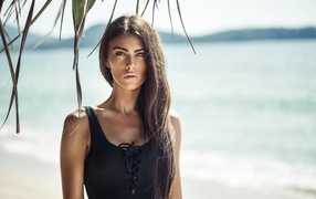 Stylish brunette with long hair on the beach