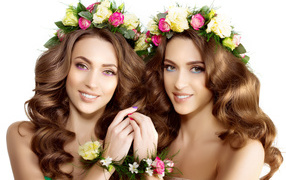 Two beautiful girls with flowers wreaths on their heads