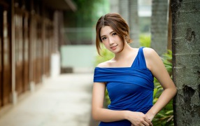 Молодая девушка азиатка в красивом голубом платье