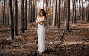 Молодая девушка в белом платье в лесу 