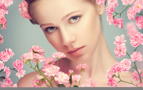 Молодая нежная девушка с розовыми розами на сером фоне