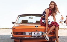 Молодая девушка популярная модель Джиджи Хадид сидит на автомобиле БМВ